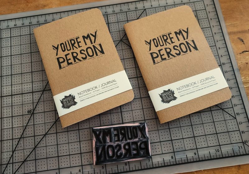 two kraft cover notebooks with the words you're my person in black ink