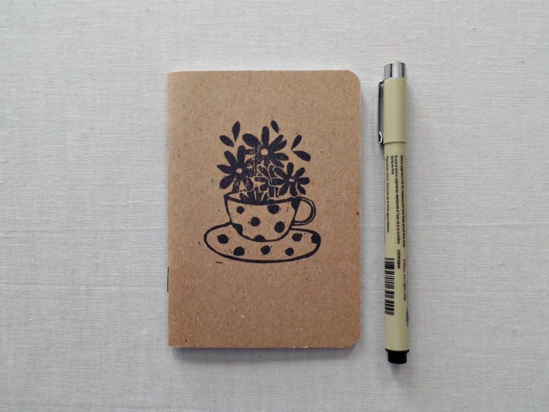 hand printed notebook with image of polka dot tea cup and flowers with pen