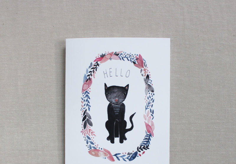 closeup of blank note card with black cat and flowers