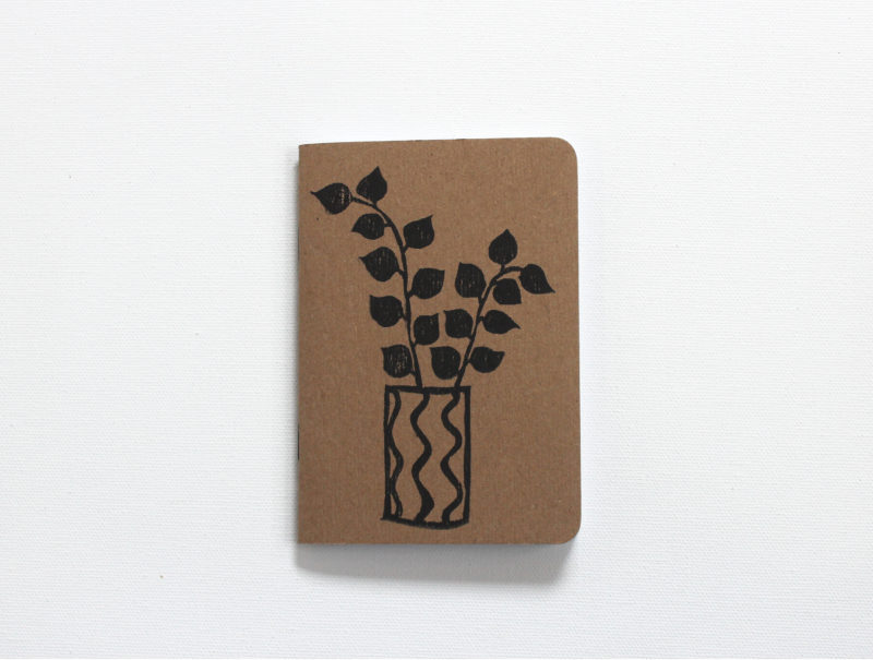 black printed houseplant in a pot on a pocket notebook