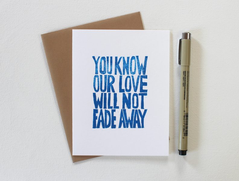 you know our love will not fade away hand printed cards in blue ink on a white card with a kraft envelope and shown with a pen by messy bed studio