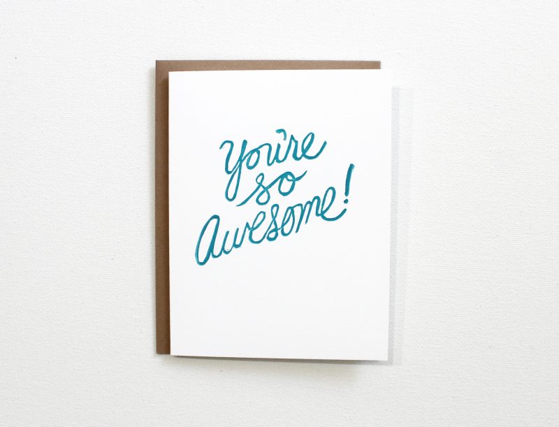 you're awesome card block printed in script in turquoise ink on a white card with and kraft envelope