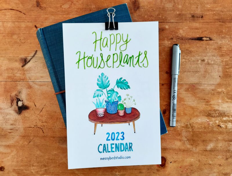 Houseplants calendar for 2023 with metal clip shown on book with pen