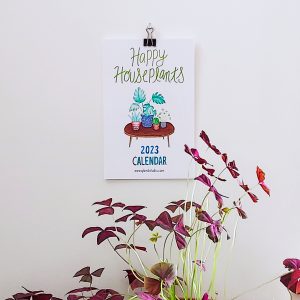 Houseplants calendar 2023 hanging on shown with a plant